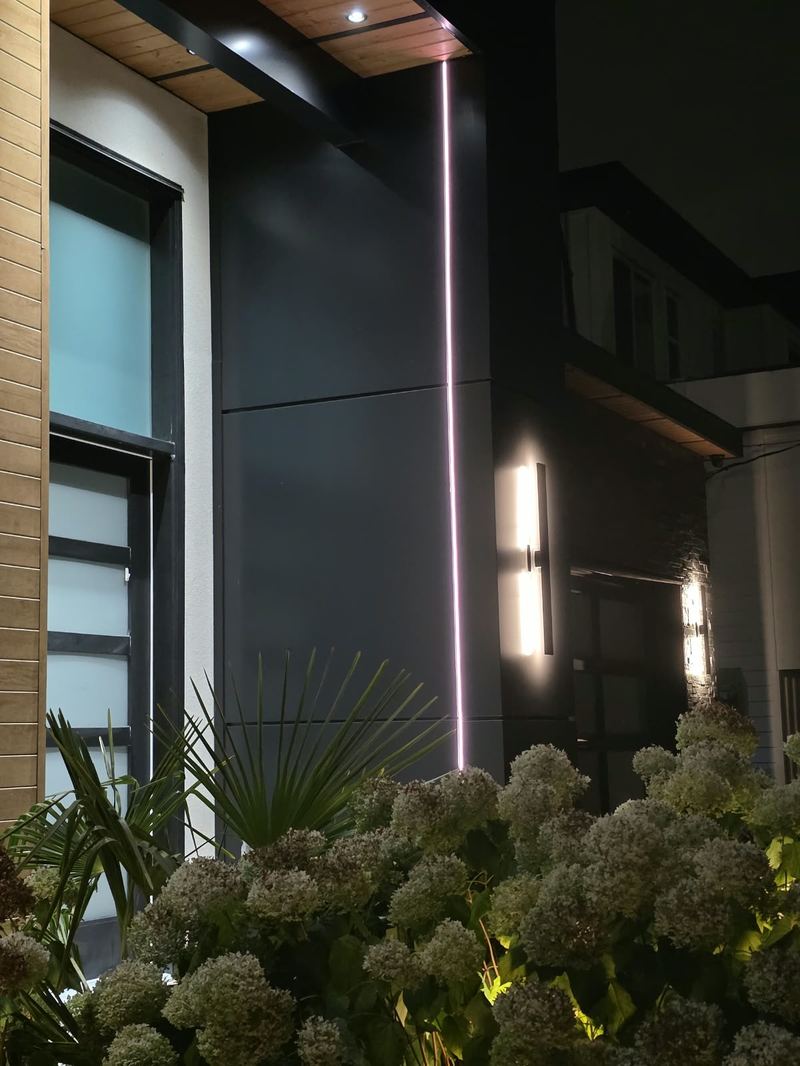 Close-up of a vertical linear accent light and wall sconces on a Delta, BC home's entryway
